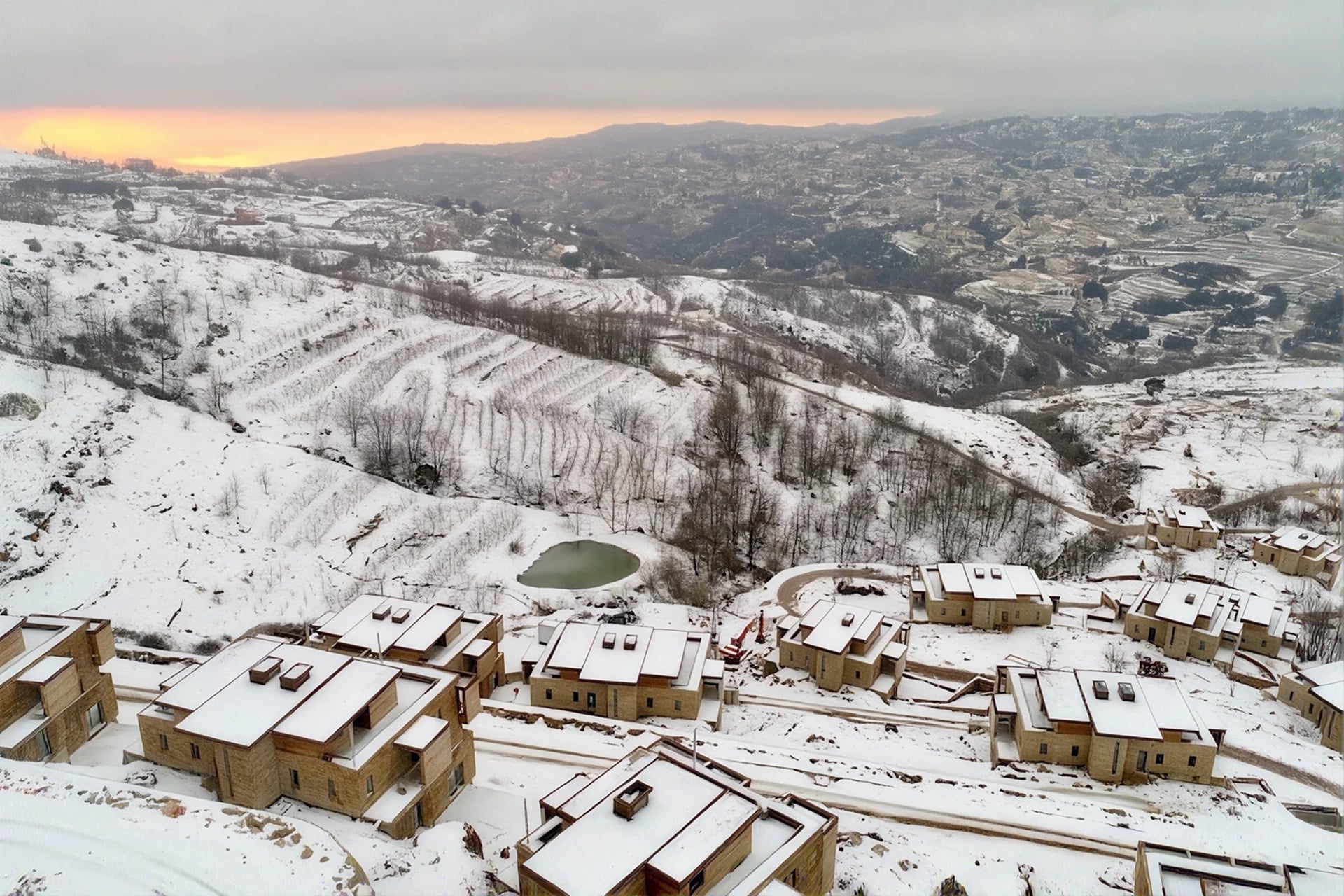 RedRock chalets under snow above Faqra at dusk